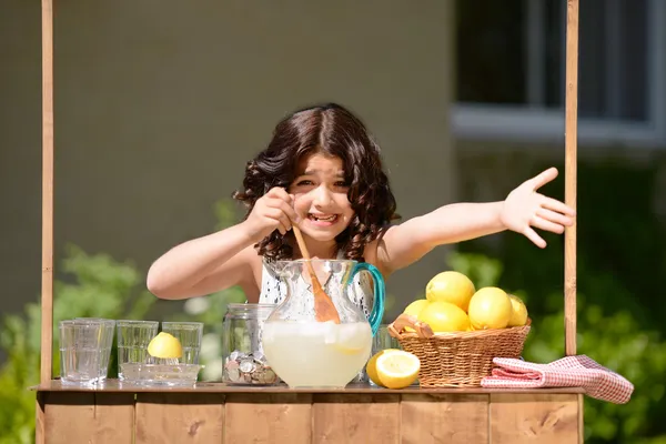 Маленькая девочка, пытаясь продать лимонад — стоковое фото