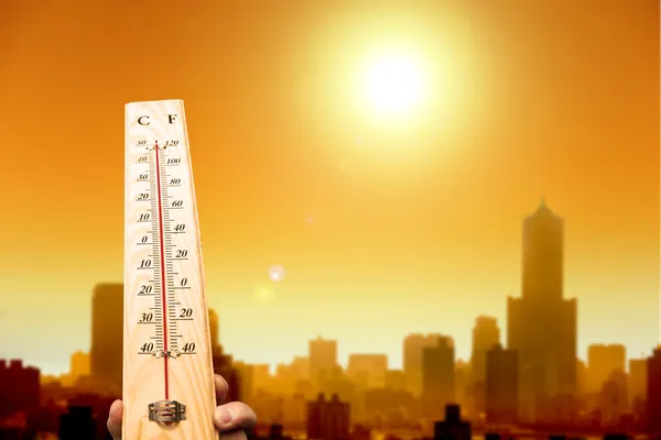 Волна тепла в городе и рукой Показываю термометр для высокой температуре — стоковое фото