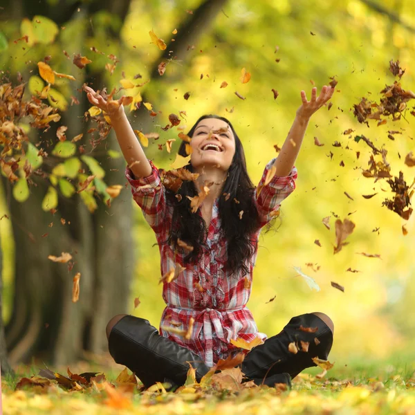 Женщина падение листьев в Осенний парк — стоковое фото