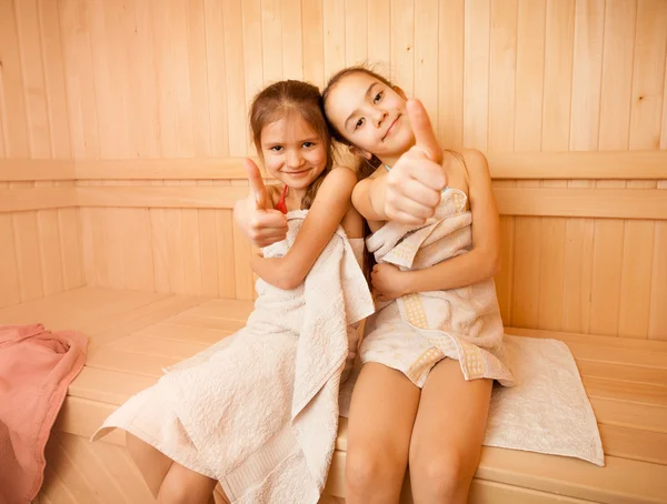 Счастливые девочки в сауне показывает палец вверх — стоковое фото