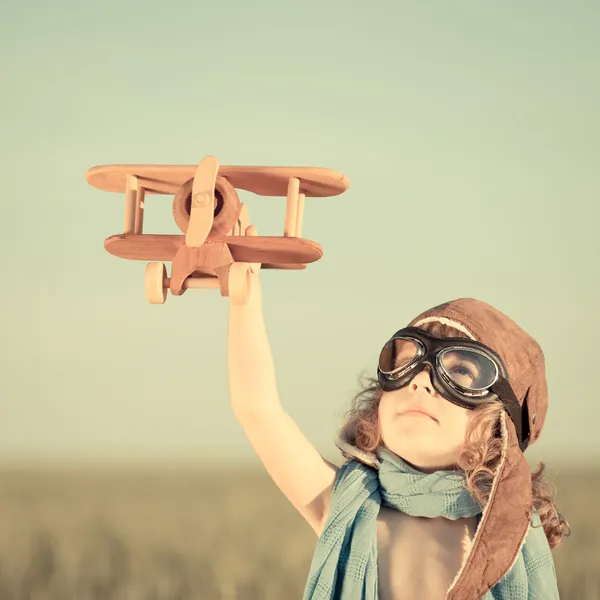 Счастливый ребенок, играющий с игрушечным самолетом — стоковое фото