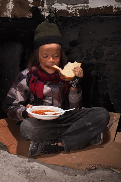 Еды на улице бездомных мальчик — стоковое фото