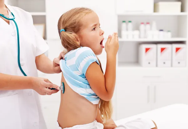 Маленькая девочка, кашель у врача — стоковое фото