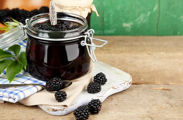 Вкусные blackberry jam и свежие ягоды, на деревянном столе Лицензионные Стоковые Фото