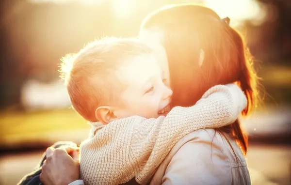 Мать, обнимая своего ребенка в парке — стоковое фото