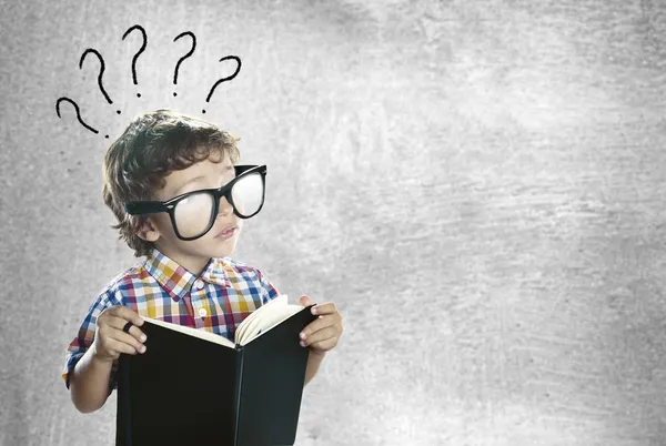 Ребенок с книгой, ища ответы Стоковое Фото