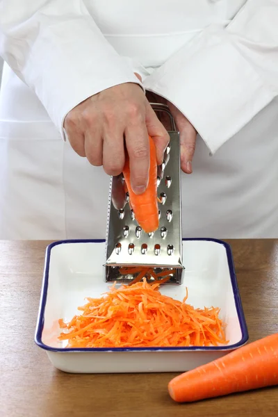 Делая салат тертой моркови, измельчения моркови — стоковое фото