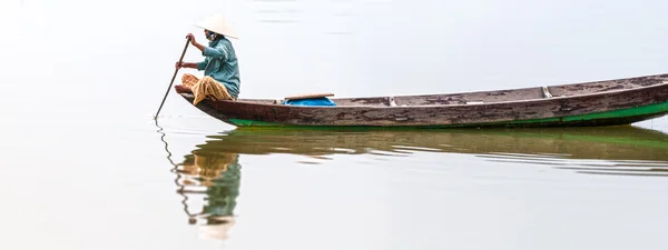 Женщина на деревянной лодке в реке Лицензионные Стоковые Изображения