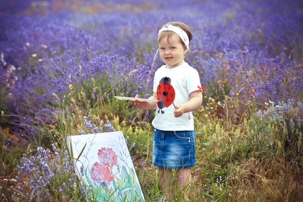 Девушка рисует картину в лавандового поля — стоковое фото