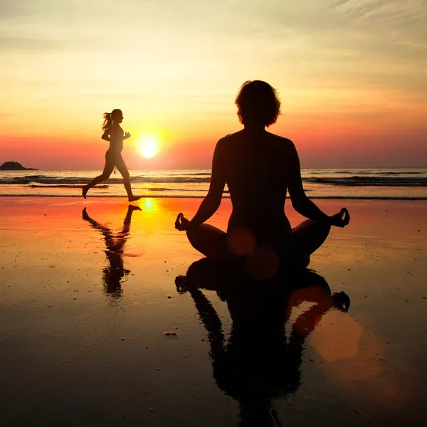 Концепция здорового образа жизни: силуэт женщины, размышляя на пляж на закате — стоковое фото