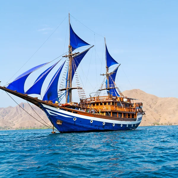 Старинный деревянный корабль с синий паруса — стоковое фото