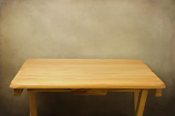 Деревянный стол над гранж-фон — стоковое фото
