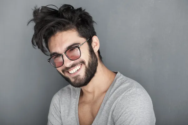 Сексуальный мужчина с бородой, улыбаясь большой стене — стоковое фото