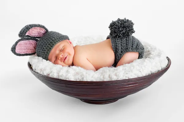 Новорожденный мальчик, носящий уши кролика и хвост кролика — стоковое фото