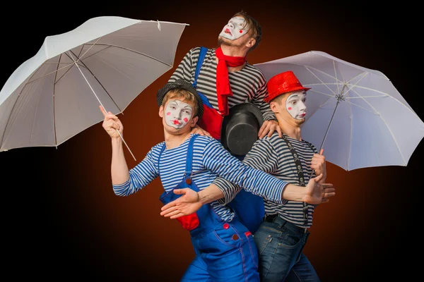Клоуны с зонтиками — стоковое фото