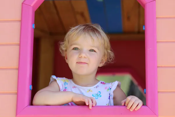 Счастливый маленькая девочка с удовольствием в playhouse в летний день Стоковое Фото