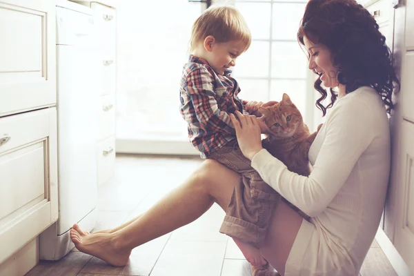 Мать и ребенок, играющий с кошкой — стоковое фото