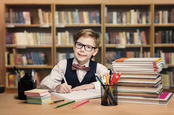 School Kid Studying in Library, Child Writing Book — стоковое фото