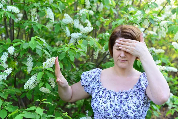 Взрослая женщина с головной болью о цветет Черемуха весной — стоковое фото