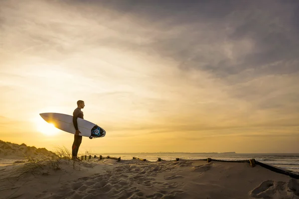 Серфер на дюны, глядя на волны — стоковое фото