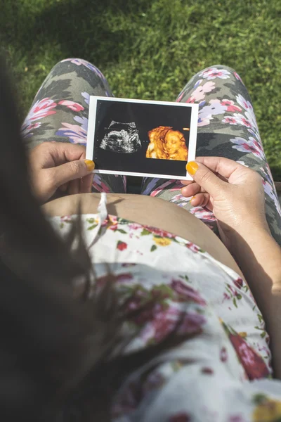 Беременная женщина, держащая картину лоно — стоковое фото