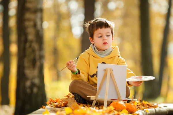 Милый маленький мальчик, живопись в Золотой Осенний парк — стоковое фото