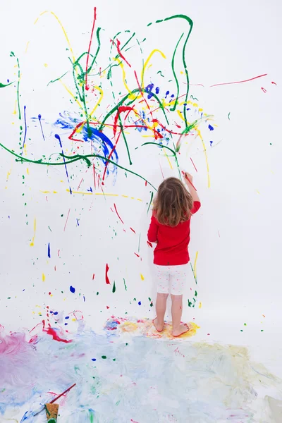 Молодой маленький малыш живопись на белой стене большой — стоковое фото