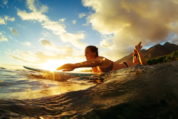 Женщина, серфинг на закате — стоковое фото