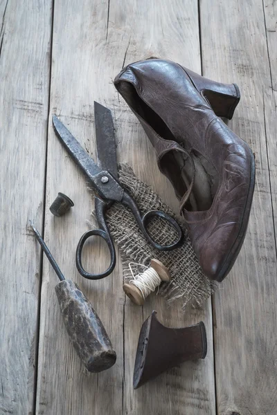 Старые изношенные ботинки и инструменты для восстановления — стоковое фото
