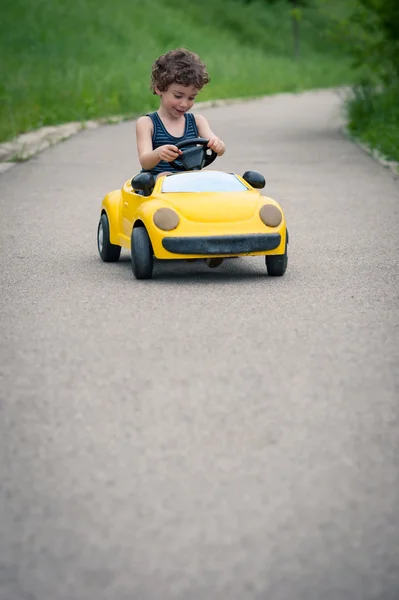 Молодой парень, играя с игрушечный автомобиль на улице — стоковое фото