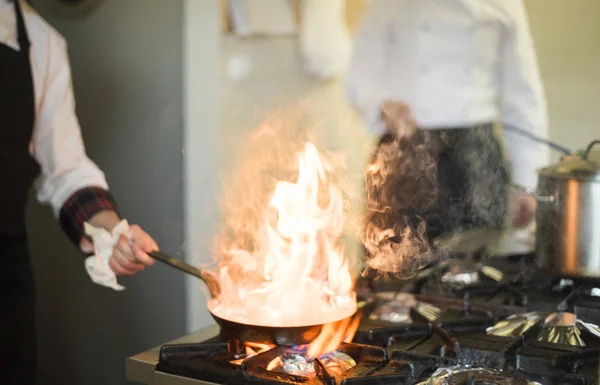 Шеф-повар сковороду на огонь — стоковое фото