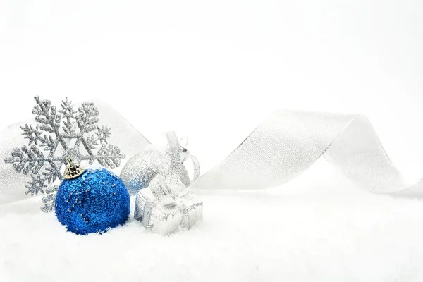 Серебро и сuний блестящие безделушки Рождество с лентой на снегу — стоковое фото