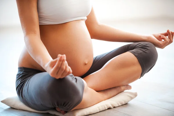 Беременная женщина, медитируя в позе лотоса — стоковое фото