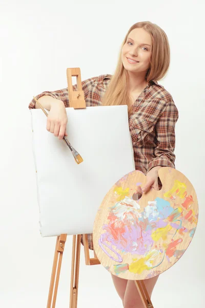 Молодая красивая художница, позирующая с мольбертом рисунка и палитрой — стоковое фото