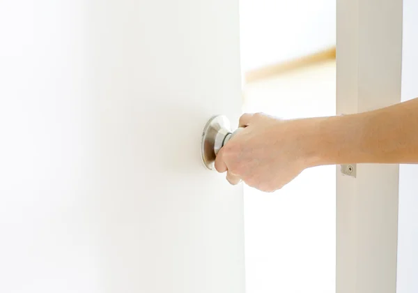 Рука открытия ручку двери, белая дверь — стоковое фото