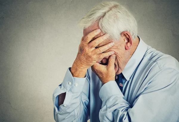 Грустно депрессии старший, старый человек, охватывающий его лицо руками — стоковое фото