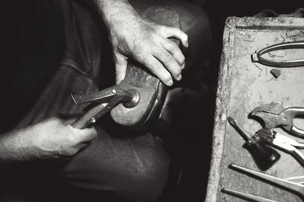 Старый башмачник хит обувь с молотка в своей мастерской — стоковое фото