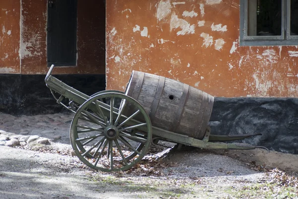 Старый ствол для хранения жидкостей, расположенный в тачку с деревянными колесами — стоковое фото