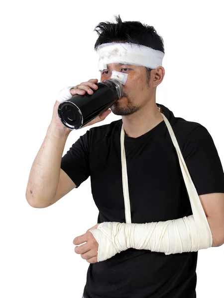 Человек со сломанной рукой, выпивать бутылку воды изолированы — стоковое фото