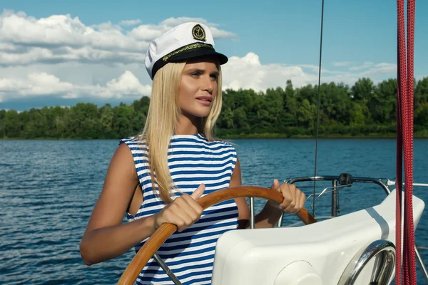 Красивая молодая блондинка женщина у руля корабля — стоковое фото