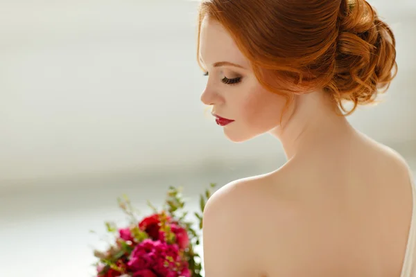 The refined portrait of red-haired girl in profile with a bouque — стоковое фото