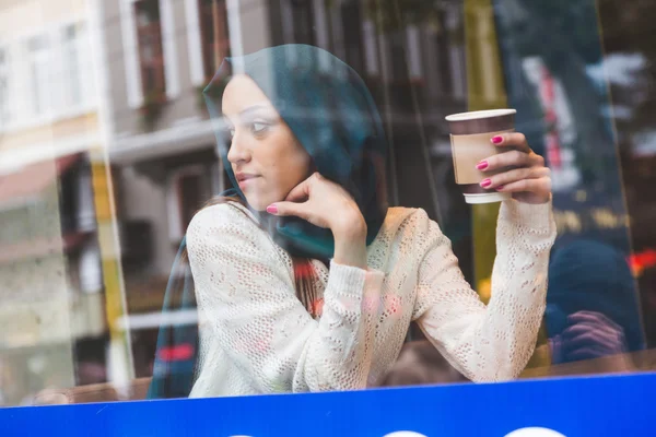 Мусульманская женщина за окном кафе — стоковое фото