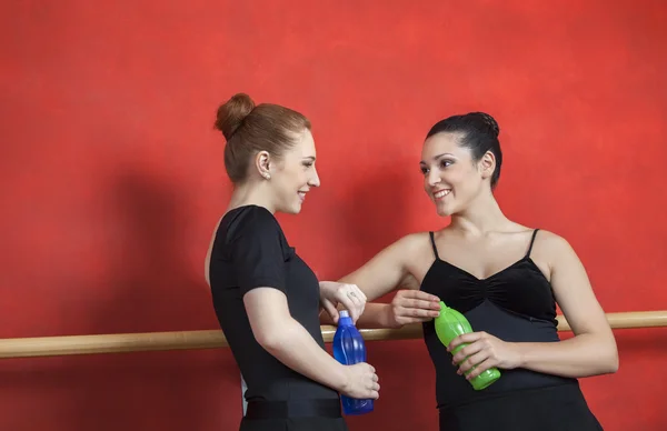Друзья, держа бутылки воды в балетной студии — стоковое фото
