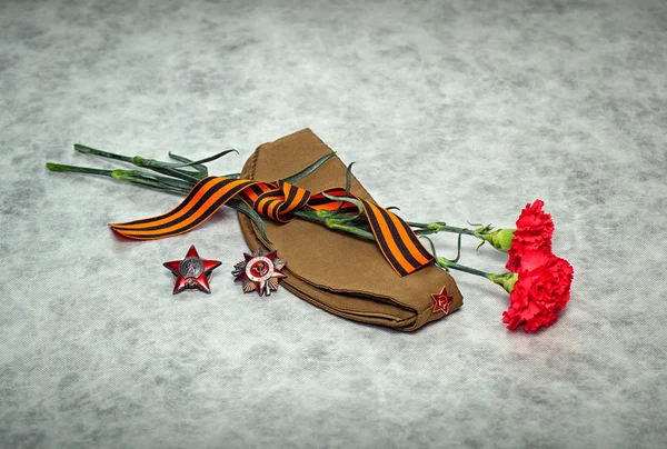 Гвоздики цветы, Джордж ленты, кормовые cap, орденами и медалями. День Победы - 9 мая — стоковое фото