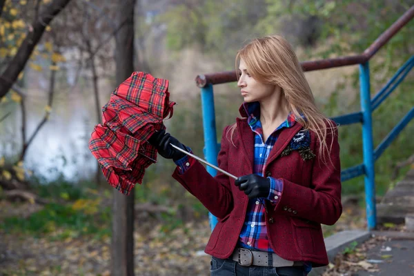 Стильная блондинка в красном жакете открывает зонтик Стоковое Фото