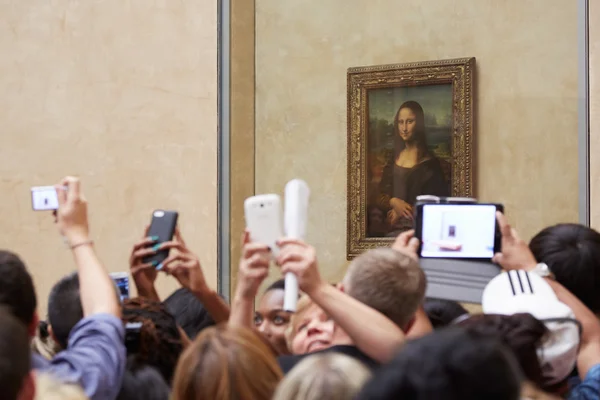 Туристов принимают фотографии «Мона Лиза» в музее Лувр в Париже Лицензионные Стоковые Изображения
