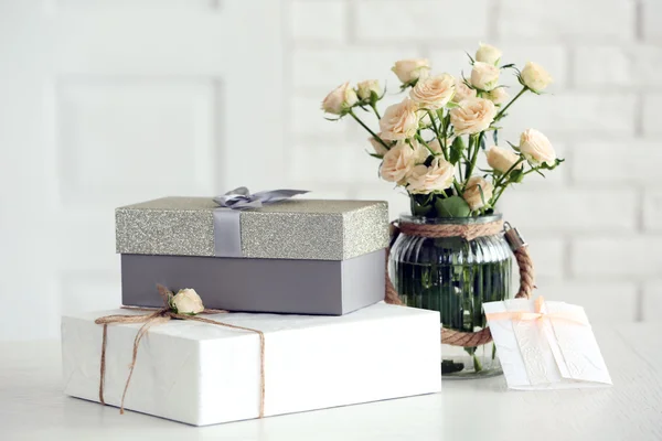 Красивый подарок коробки с букетом цветов на столе перед кирпичной стены, крупным планом — стоковое фото