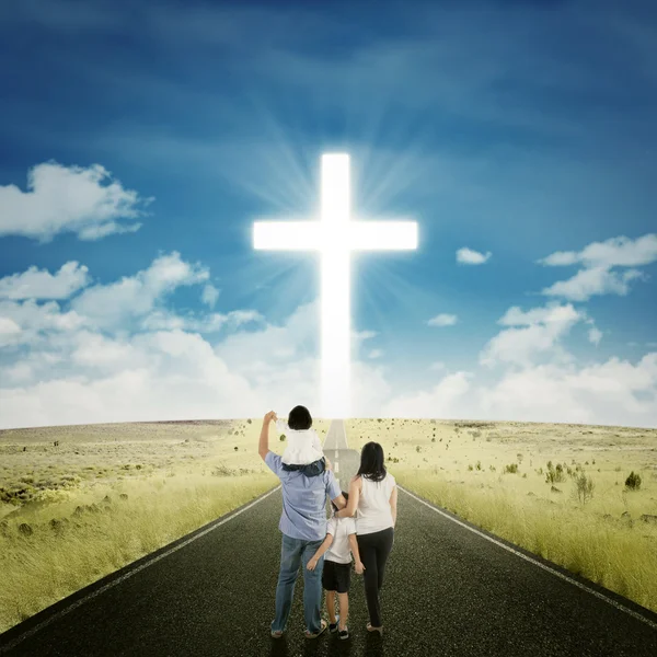 Родители и дети на дороге с крестом — стоковое фото