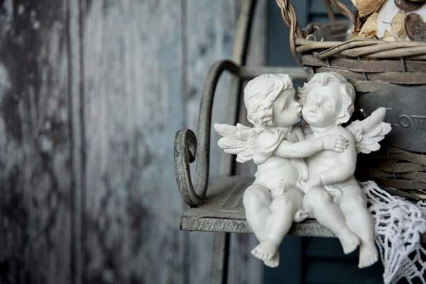 Люблю фигурки ангелов, сидя на скамейке — стоковое фото