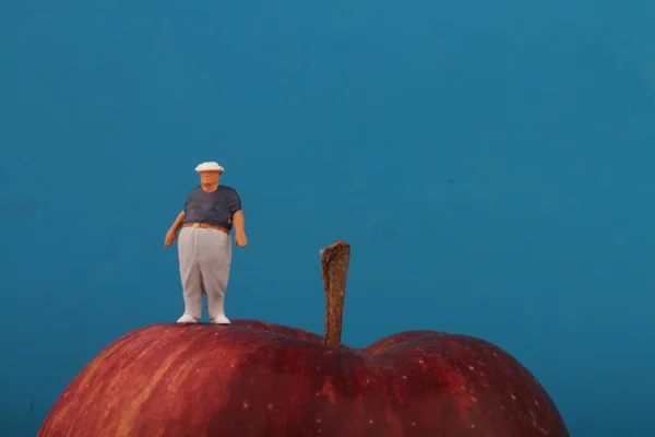 Толстяк на вершине красного яблока - ожирение концепции — стоковое фото
